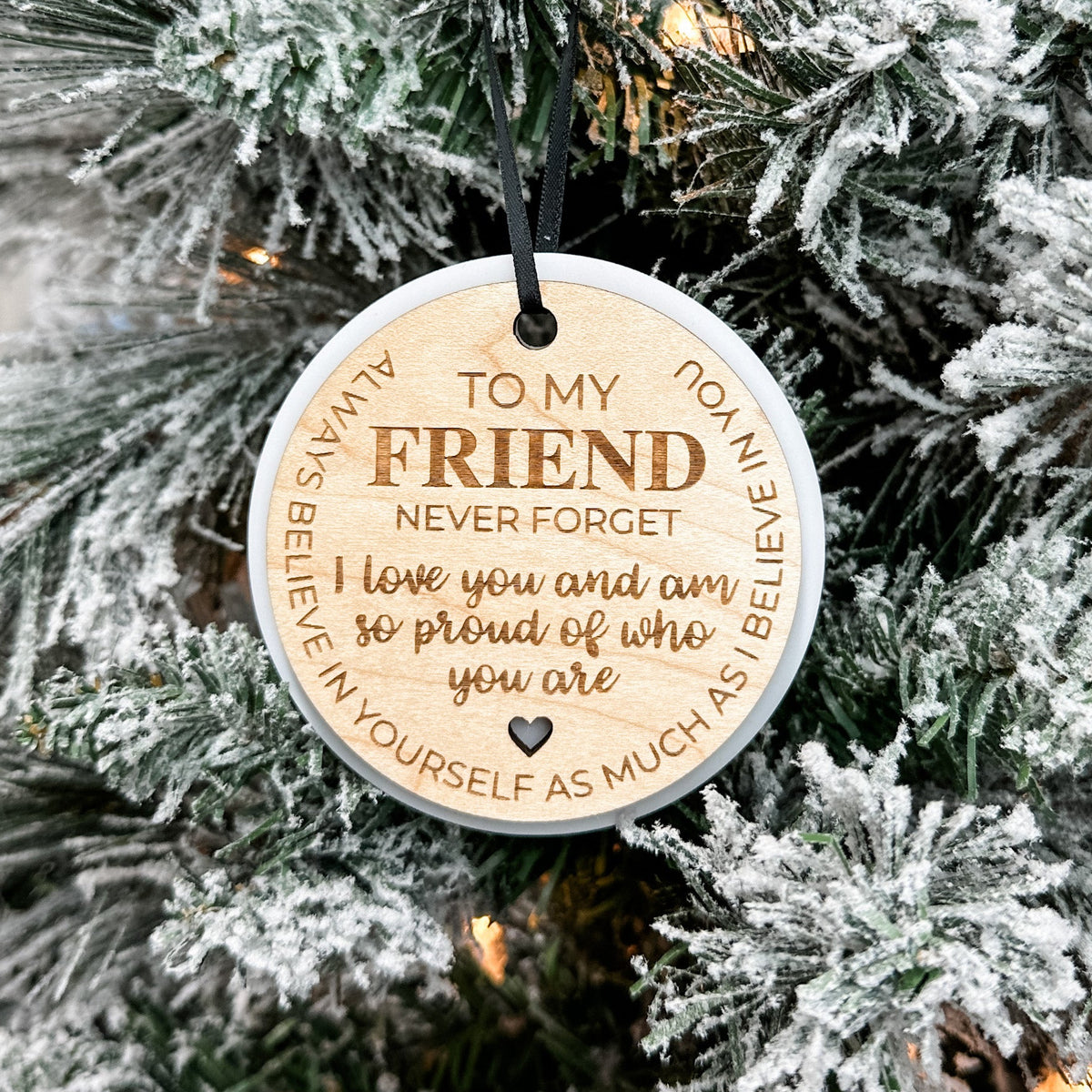 Round wooden ornament with engraved message on a Christmas tree
