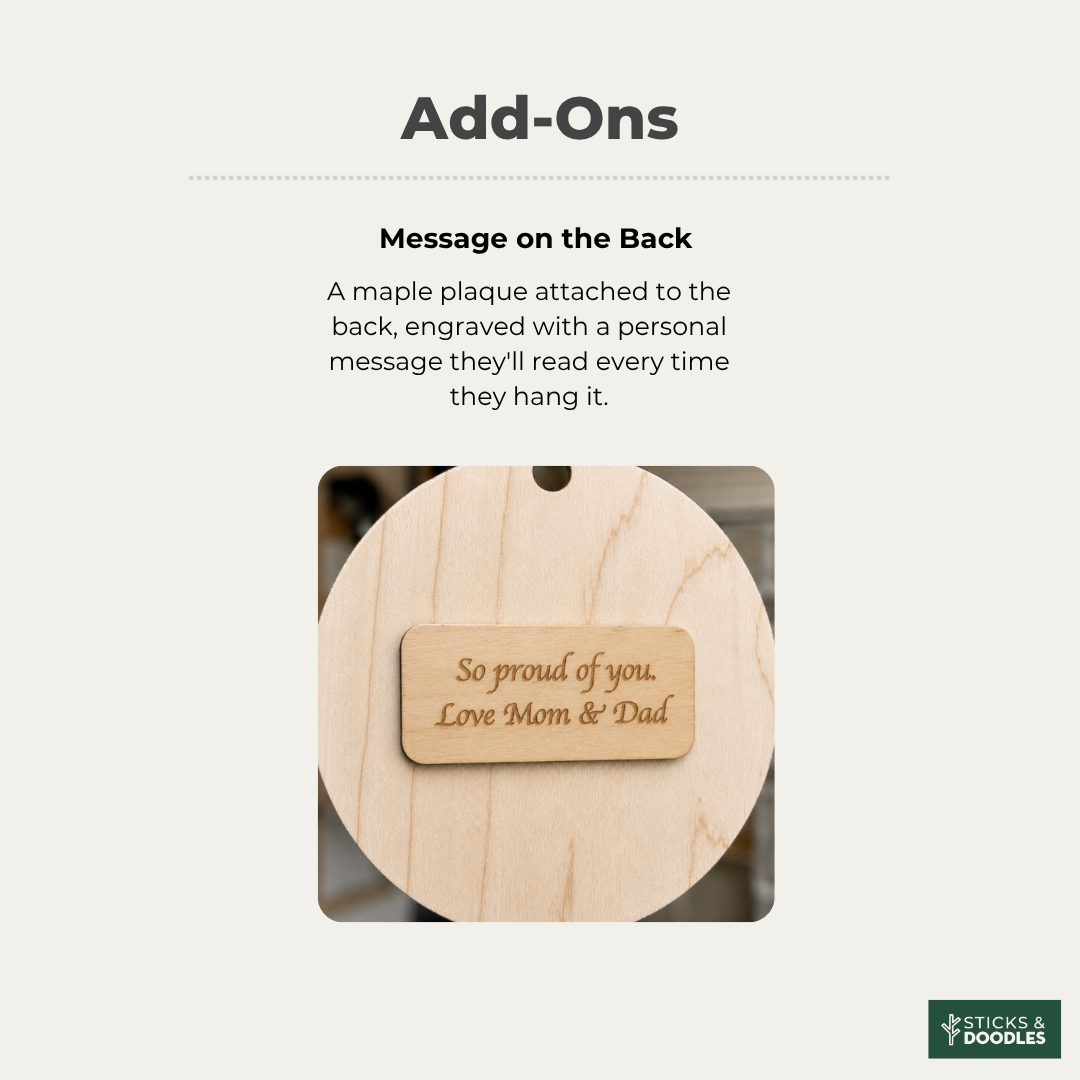 Add-on graphic showing a round natural wood maple plaque with a small engraved wooden tag that reads 'So proud of you. Love Mom & Dad.